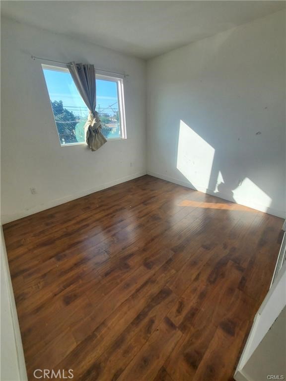 437 North Fries Avenue, Unit 1 Wilmington, CA 90744 - Photo 10 of 14 an empty room with wooden floor and windows
