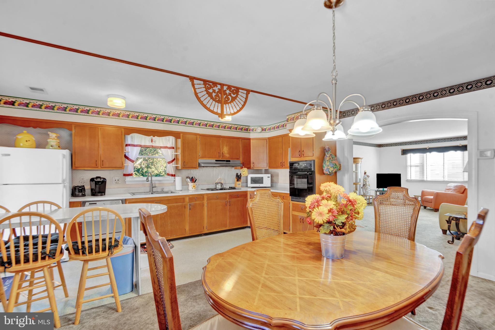 104 Gilmore Road Havertown, PA 19083 - Photo 12 of 47 a view of a dining room and livingroom with furniture wooden floor a chandelier
