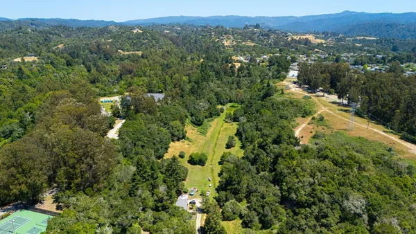 an aerial view of residential houses with yard