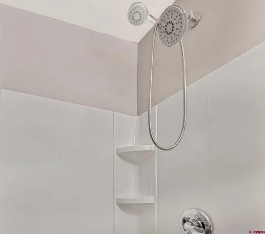 a close view of a faucet a mirror and a shower in a room