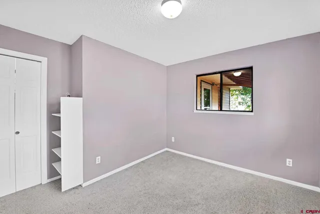 an empty room with windows and closet