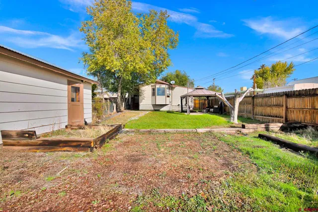 a view of a house with backyard and sitting area