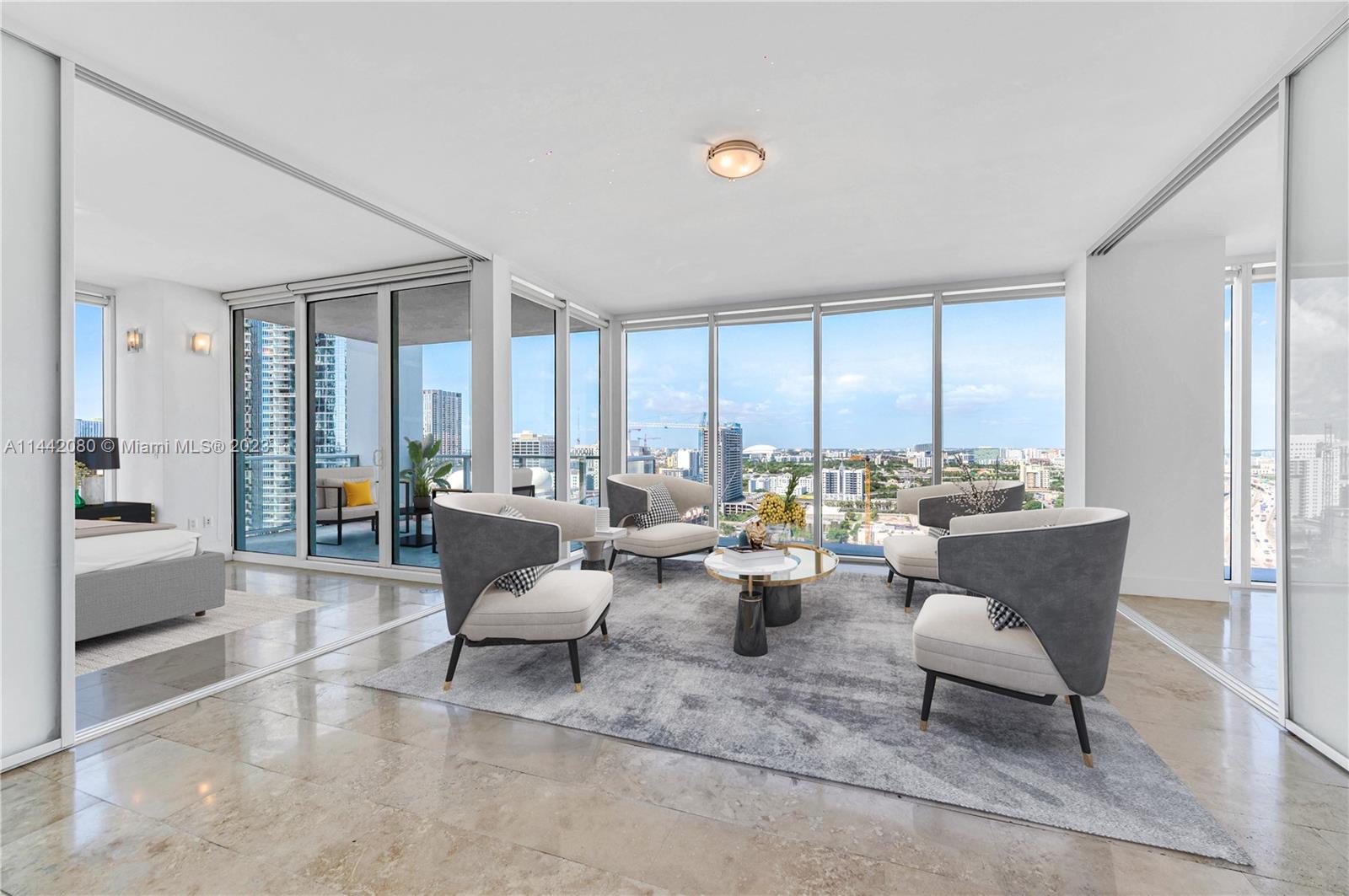 1040 Biscayne Boulevard, Unit 2107 Miami, FL 33132 - Photo 13 of 50 a living room with furniture and large windows