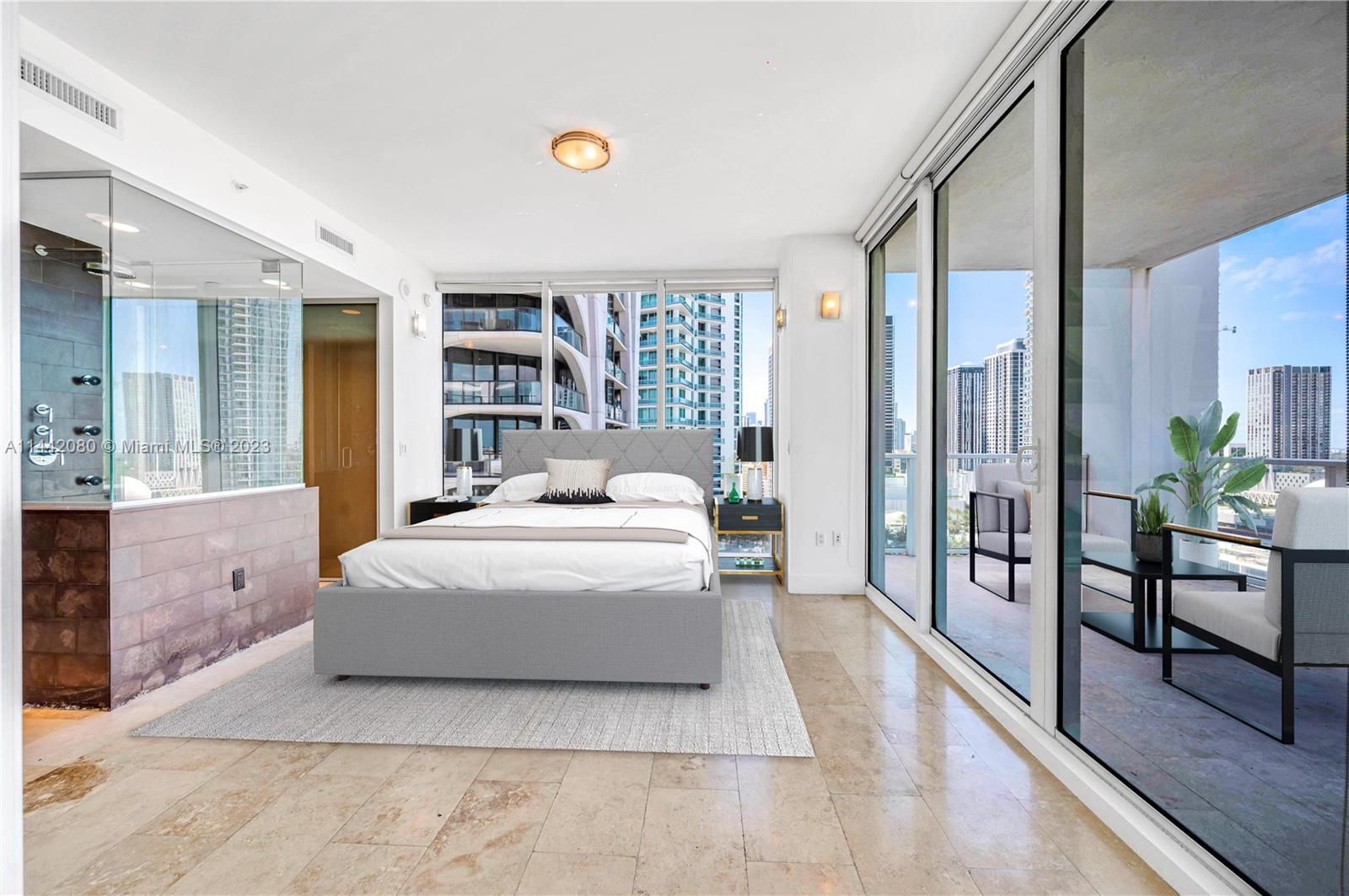 1040 Biscayne Boulevard, Unit 2107 Miami, FL 33132 - Photo 17 of 50 a spacious bedroom with a large bed and a chandelier