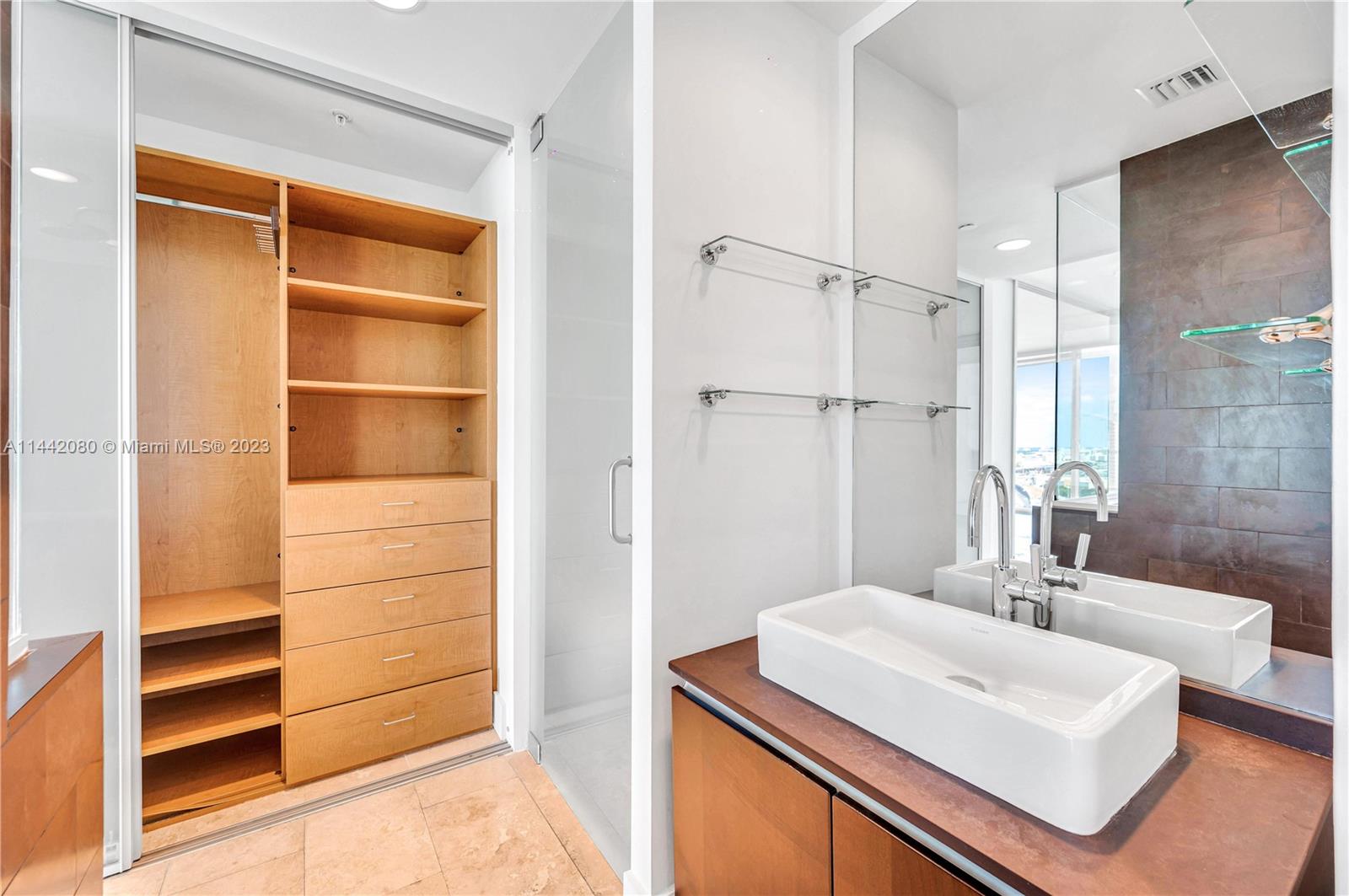 1040 Biscayne Boulevard, Unit 2107 Miami, FL 33132 - Photo 26 of 50 a bathroom with a sink a shower and a mirror