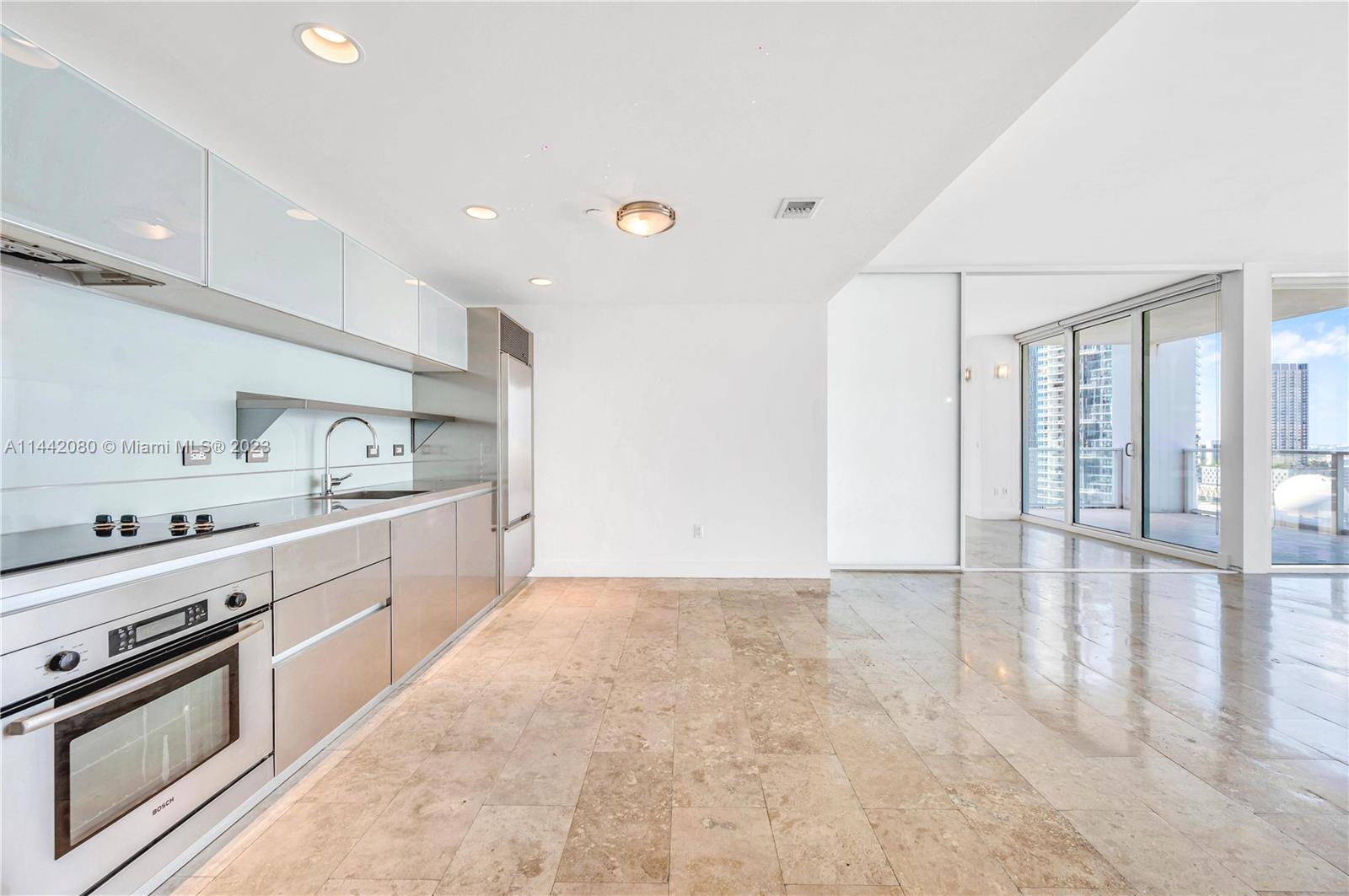 1040 Biscayne Boulevard, Unit 2107 Miami, FL 33132 - Photo 4 of 50 a large kitchen with stainless steel appliances granite countertop a stove and a sink