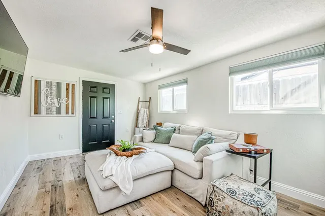 a living room with furniture and wooden floor