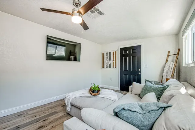 a living room with furniture and a wooden floor