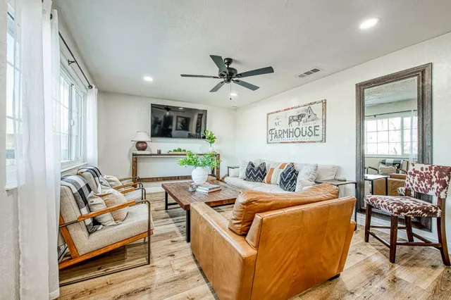 a living room with furniture a flat screen tv and a window