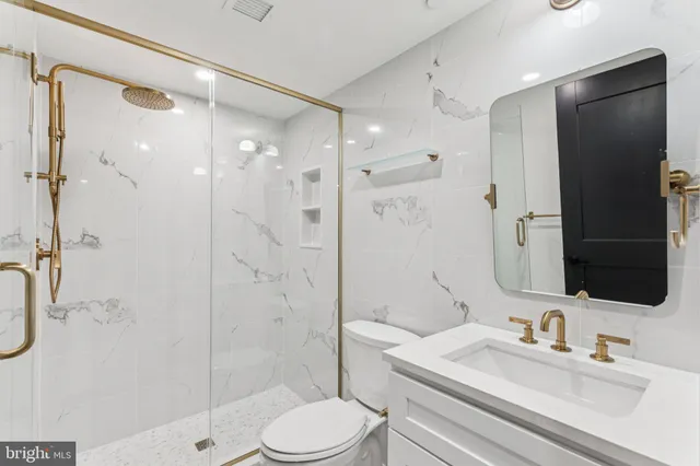 a bathroom with a sink a toilet and shower