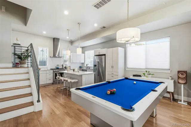 a room with pool table chairs and windows