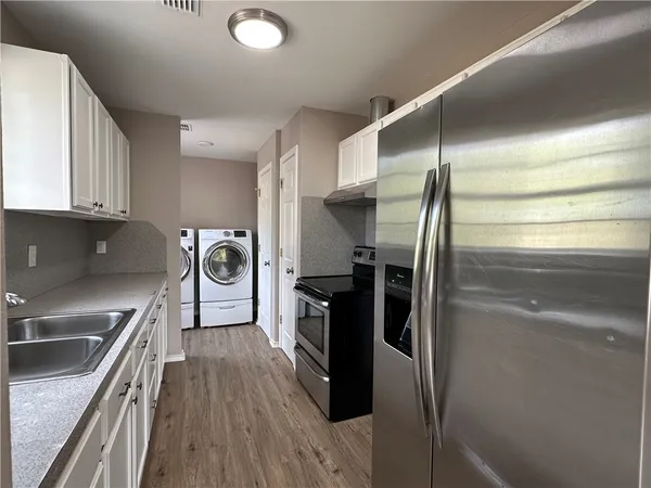 a kitchen with stainless steel appliances granite countertop a refrigerator and a sink