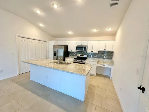 a large kitchen with stainless steel appliances lots of counter top space