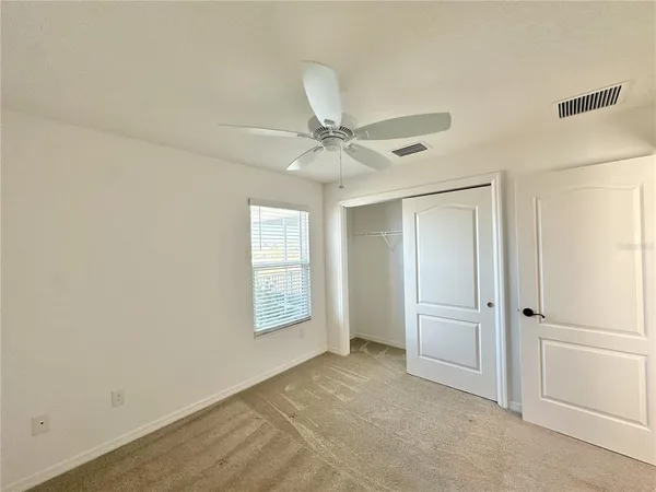 an empty room with fan and windows