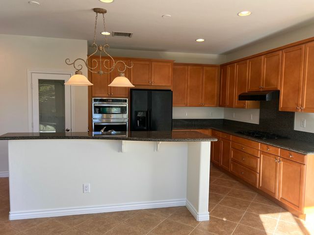 a kitchen with stainless steel appliances granite countertop a sink a stove and a refrigerator