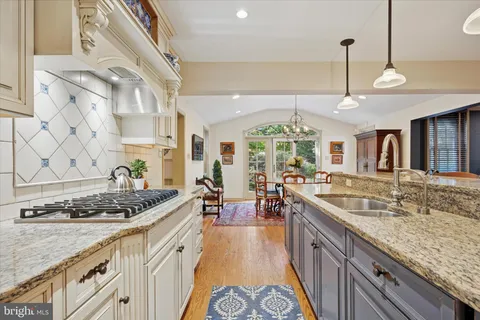 a kitchen with stainless steel appliances granite countertop a sink stove and cabinets