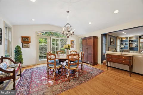 a dining room with furniture a chandelier and wooden floor
