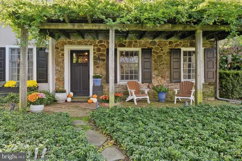 a backyard of a house with table and chairs and potted plants