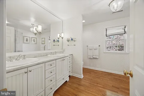 a spacious bathroom with a granite countertop sink a mirror and a shower