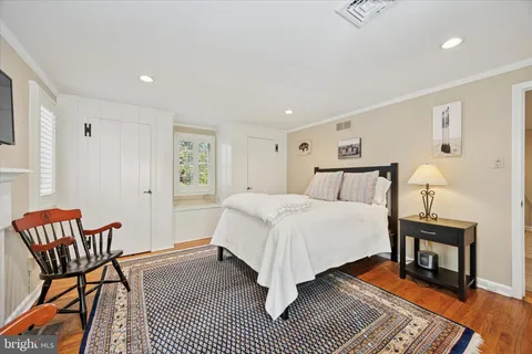 a spacious bedroom with a bed and chair