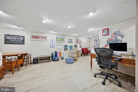 a view of a workspace with furniture and wooden floor