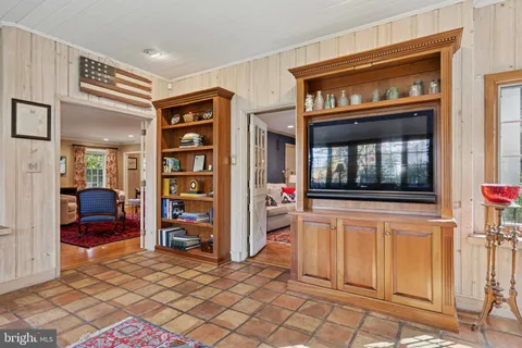 a living room with furniture a flat screen tv and a window
