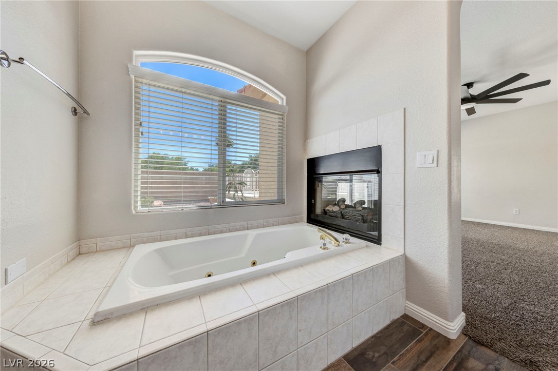 740 Aldo Rae Court, Unit NONE Henderson, NV 89052 - Photo 26 of 35 Indulge in a relaxing soak in this bath with an arched window and a cozy fireplace.