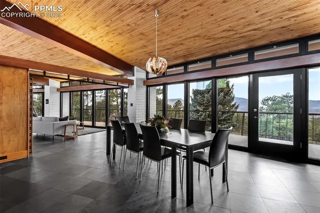 a dining room with furniture and floor to ceiling window