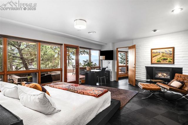 a bedroom with a bed and large windows