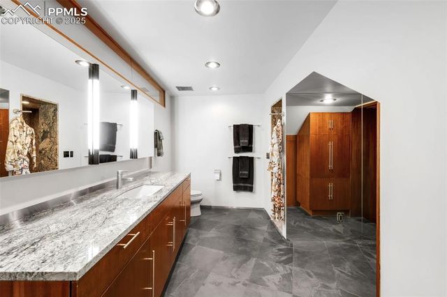a spacious bathroom with a granite countertop sink and a mirror