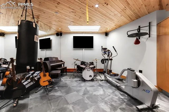 a room with furniture a flat screen tv and gym equipment
