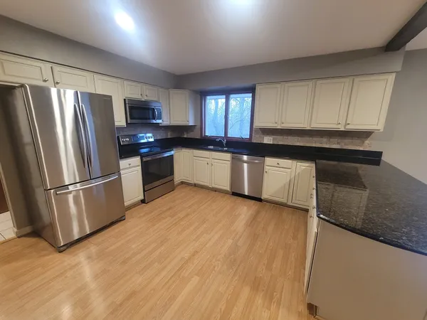 a kitchen with stainless steel appliances a refrigerator a sink a stove a microwave and island