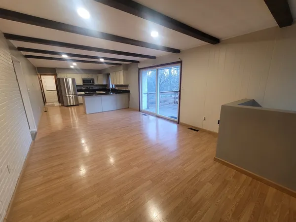 a view of a room with wooden floor