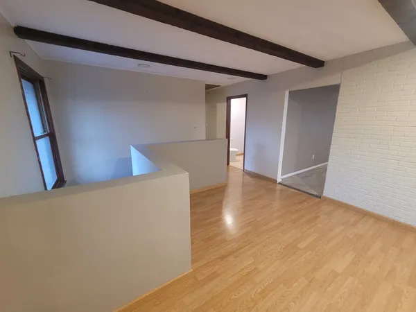 a view of an empty room with wooden floor
