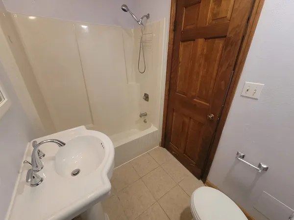 a bathroom with a tub a sink and a toilet
