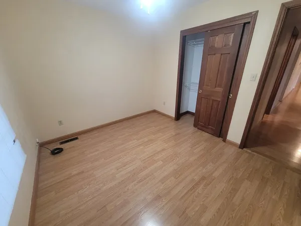 an empty room with wooden floor and a window