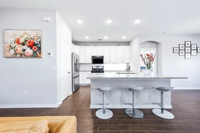 a kitchen with stainless steel appliances kitchen island granite countertop a sink and cabinets