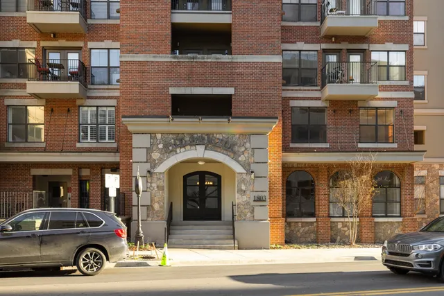 a living room with couches a table and chairs with potted plants