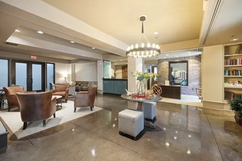 a kitchen with stainless steel appliances granite countertop table chairs and a refrigerator