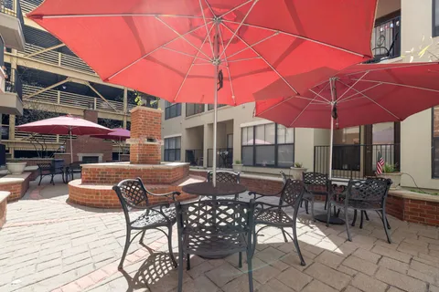 a patio with a table and chairs under an umbrella