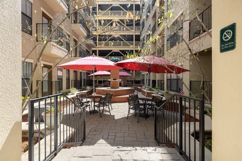 a view of a patio with chairs and umbrellas