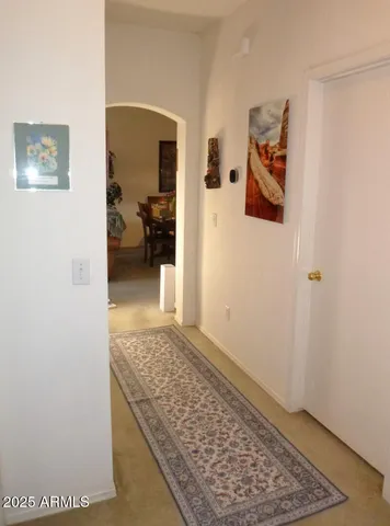 a view of a hallway with wooden floor and a rug