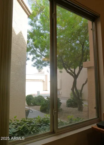 a view of a room with a large window and wooden floor