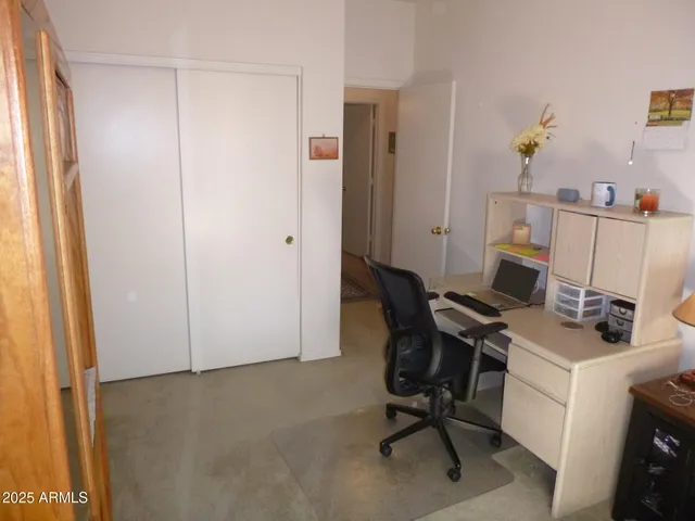 a view of a workspace with furniture and a window