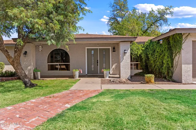 a view of a chair and table in backyard of the house