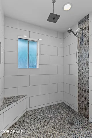 a bathroom with a granite countertop sink a mirror and shower