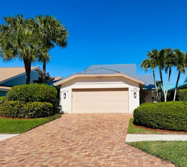 400 River Edge Road Jupiter, FL 33477 - Photo 2 of 19 a front view of a house with a yard and garage