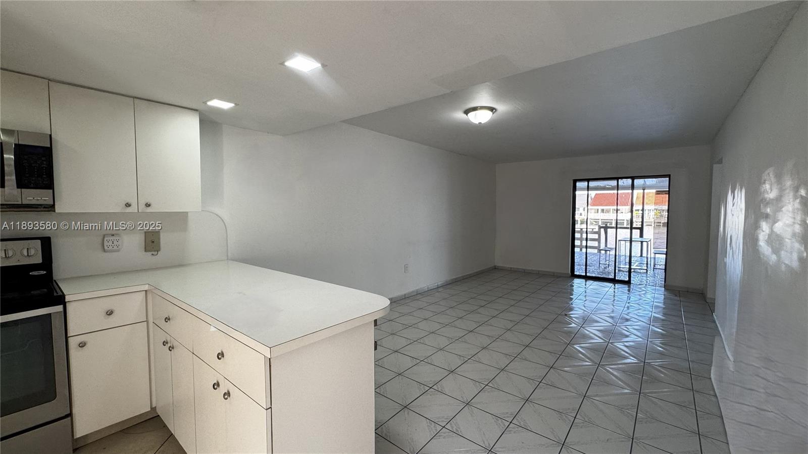 5530 West 26th Court, Unit 104 Hialeah, FL 33016 - Photo 2 of 14 a kitchen with granite countertop white cabinets and white appliances