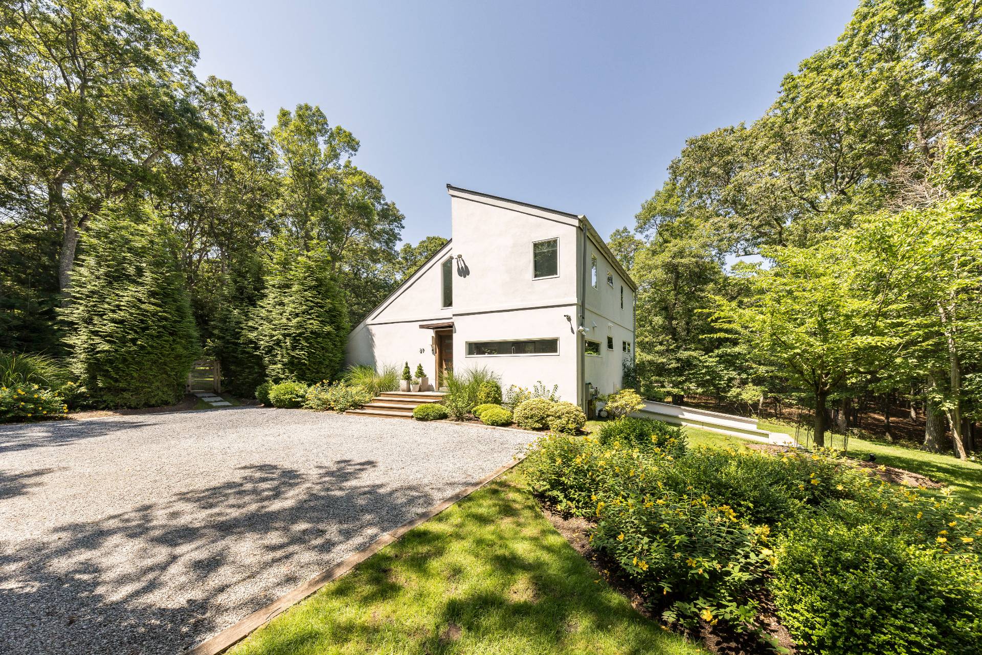 27 Landfall Road East Hampton, NY 11937 - Photo 3 of 24 a white house that has a tree in front of it