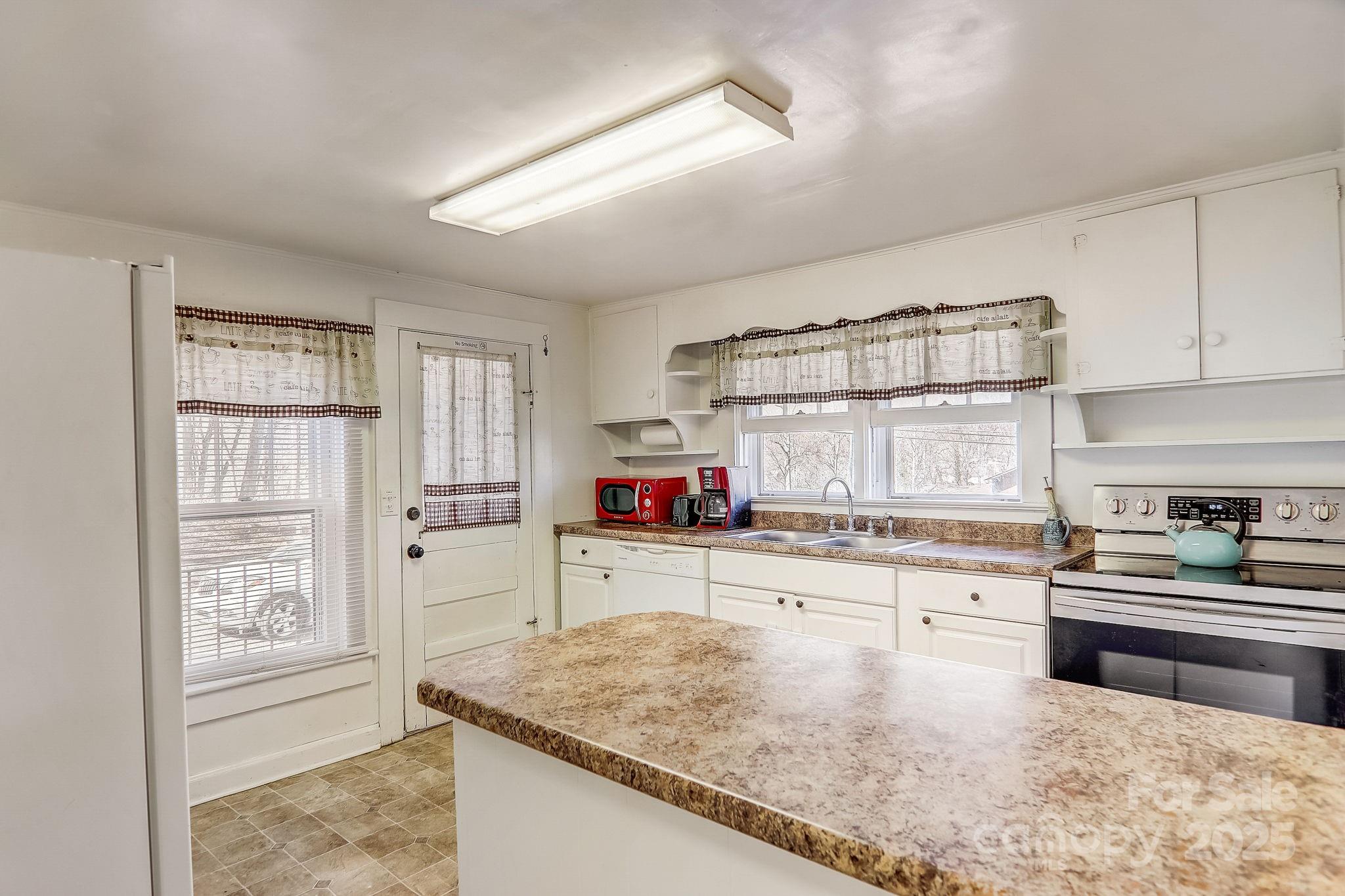 1639 Soco Road Maggie Valley, NC 28751 - Photo 7 of 15 a kitchen with stainless steel appliances granite countertop a sink stove and cabinets